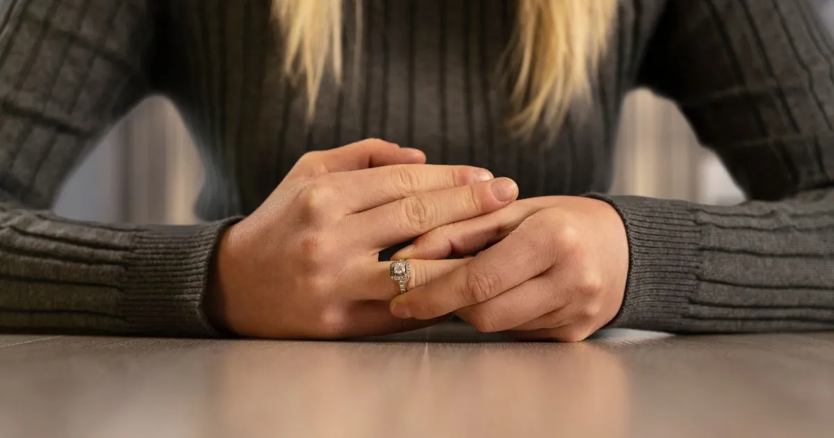 Woman taking off her wedding ring.
