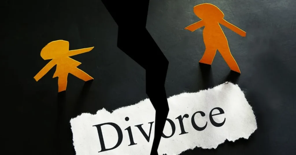 crack in the ground separating two paper human figures, symbolizing divorce.