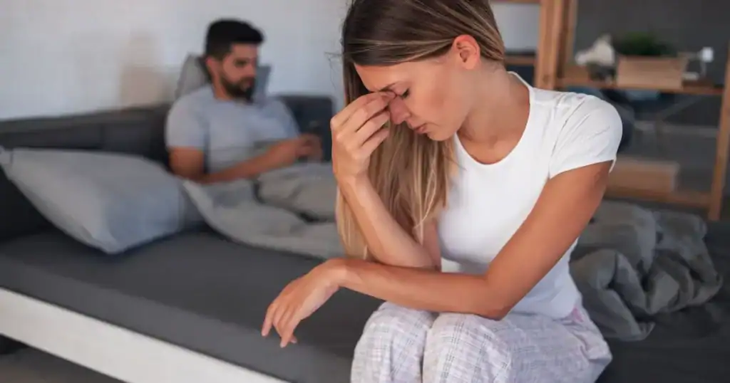 an upset lady sitting next to her husband.